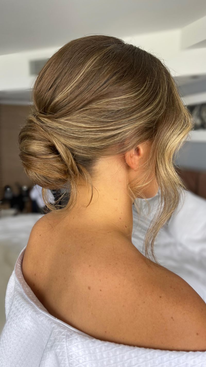 Low Messy Bun with Face-Framing Tendrils