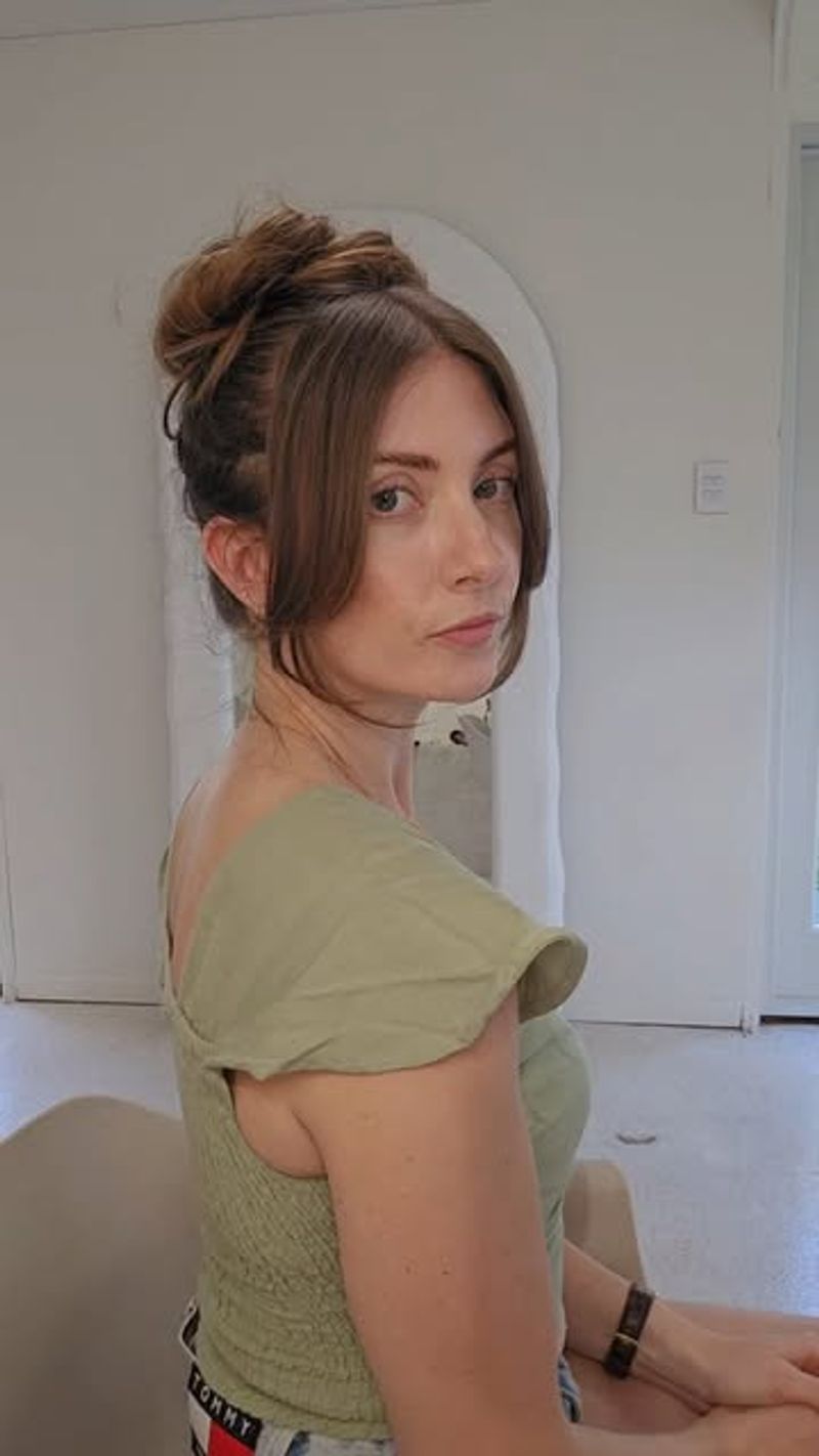 Messy Top Knot with Face-Framing Tendrils